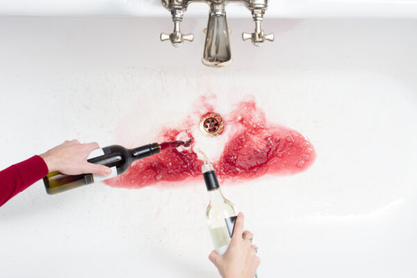 Couple pouring wine down sink to cut down on alcohol