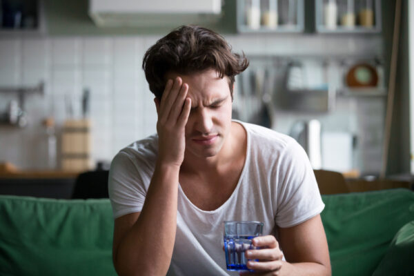 Young man with headache sickness alcohol